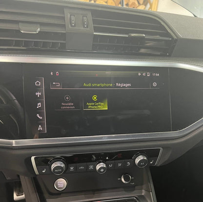 Car dashboard with infotainment system displaying Audi smartphone settings.