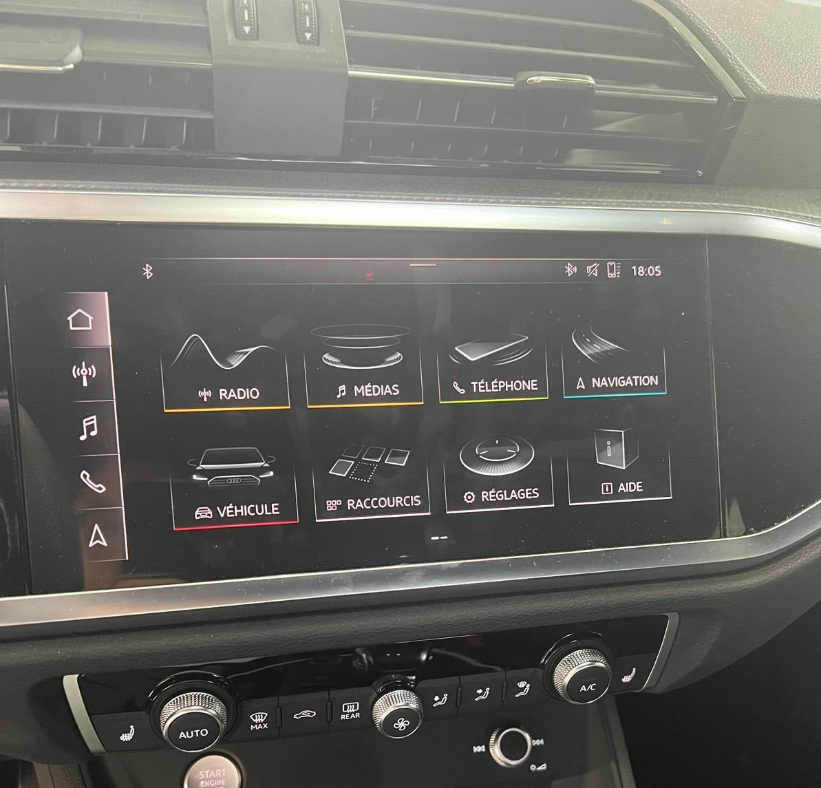 Car dashboard with a touchscreen display and control buttons.