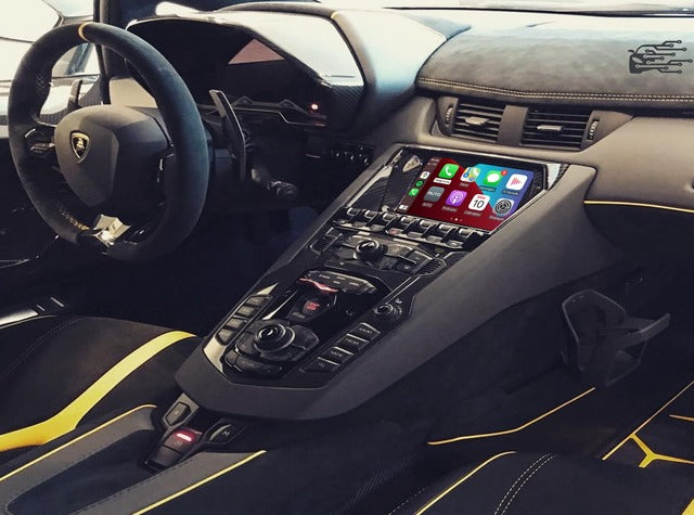 Apple CarPlay interface in a Lamborghini luxury sports car, showcasing navigation, communication, and media apps on the touchscreen.